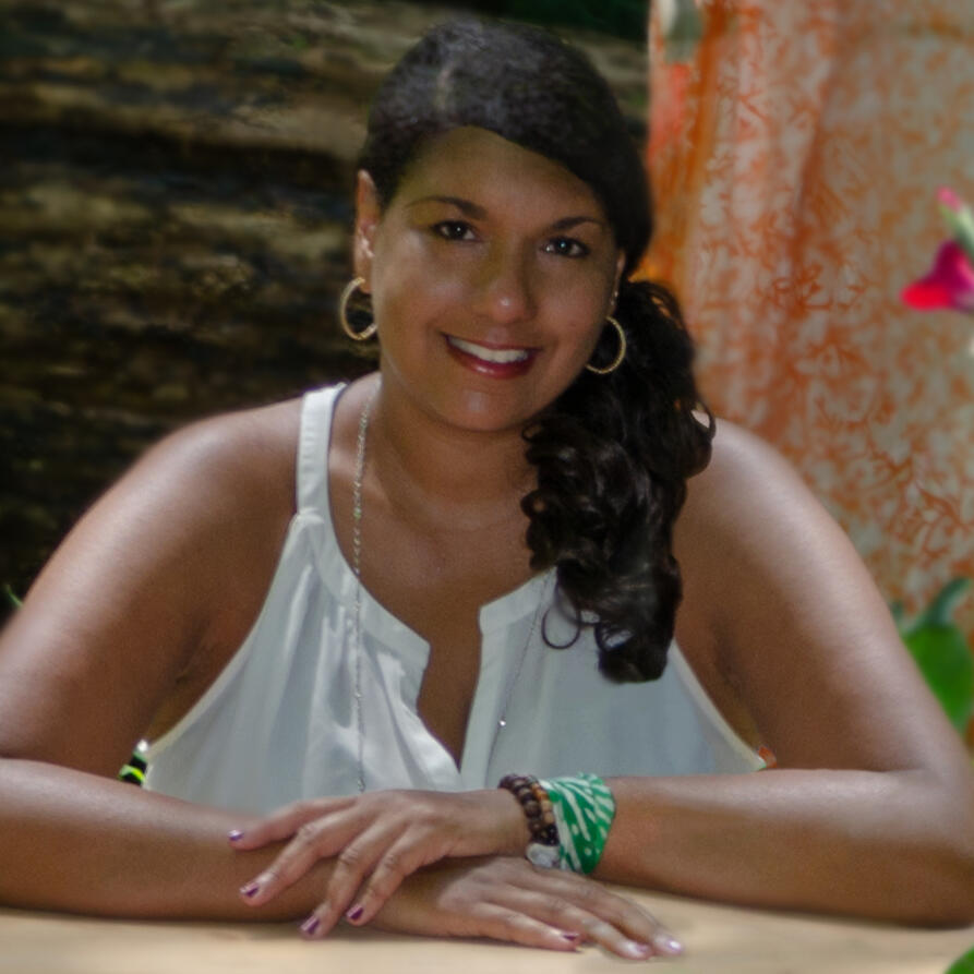 professional woman siting at a desk hands on the table smiling
